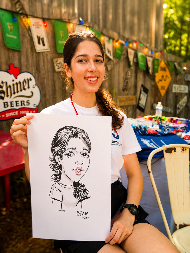 Young woman holding her caricature at an outdoor community fundraiser event