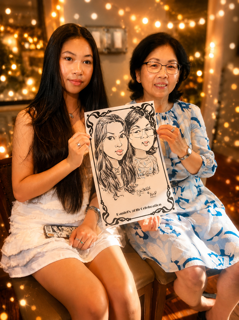 Mother and daughter duo holding a black-and-white caricature at a 50th birthday celebration